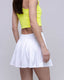 Person wearing a yellow top and white skirt on a plain background