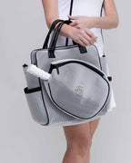 Black and white patterned bag held by a person on a plain background