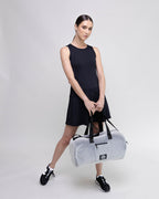 Woman holding a white duffel bag with a black background
