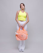 Woman holding a pink bag against a gray background
