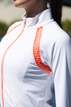 Close-up of a white shirt with orange accents worn by a person.