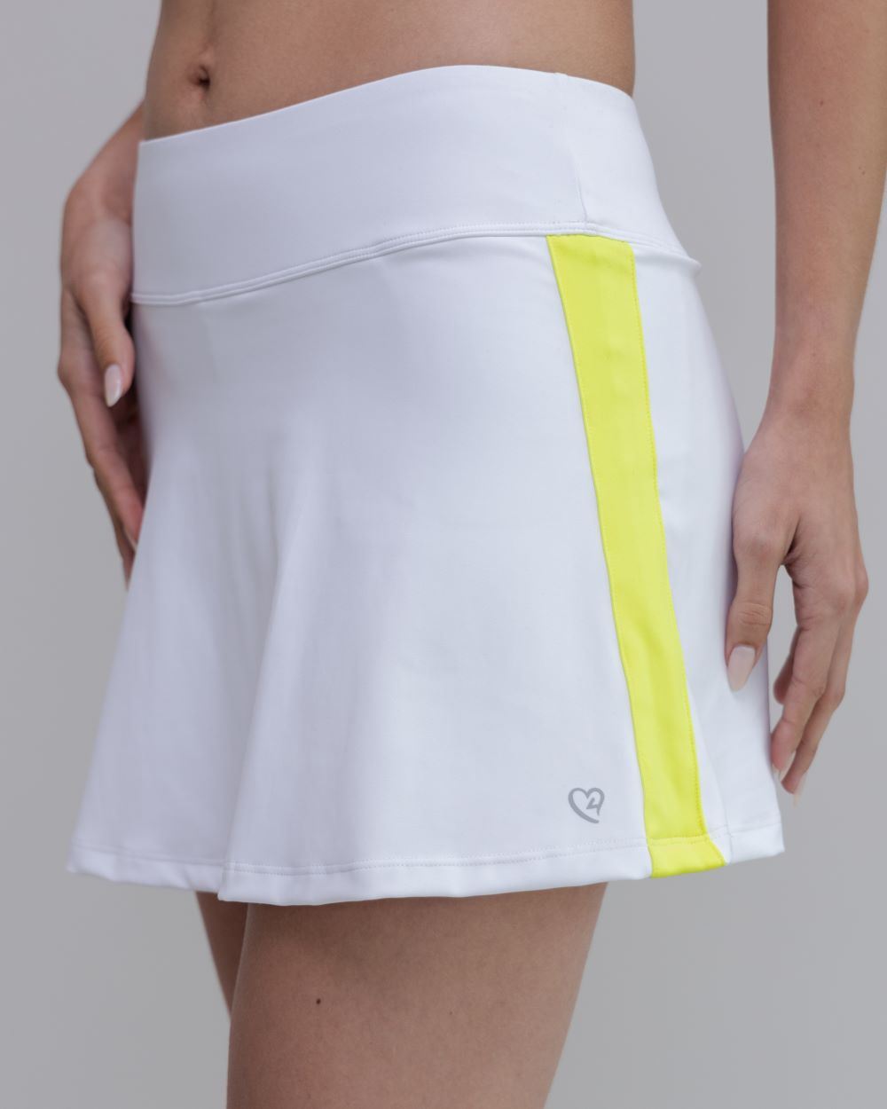 White athletic skirt with a yellow stripe on a neutral background