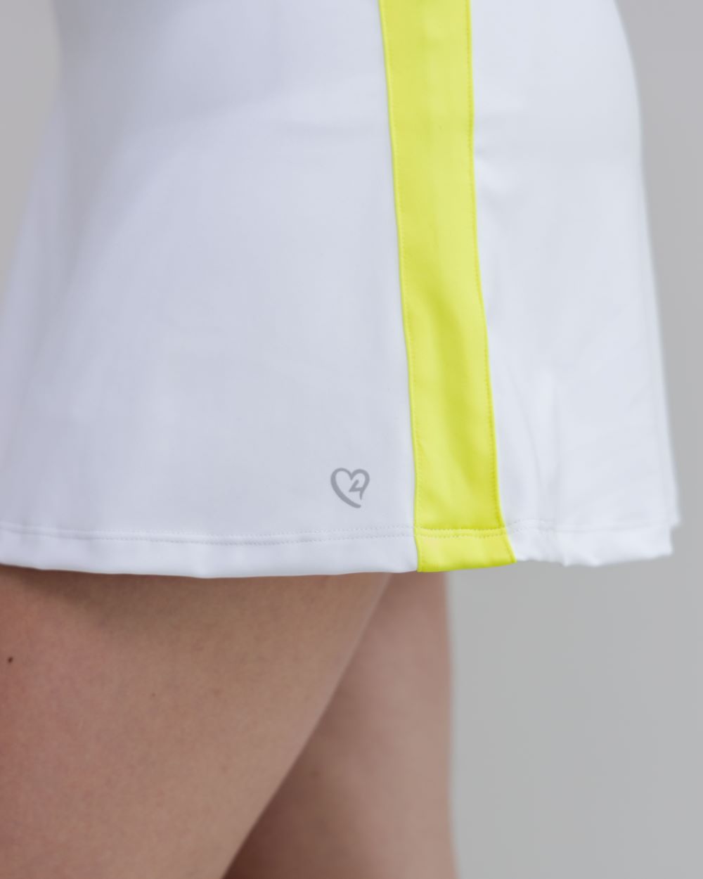 White shorts with a yellow stripe and a heart logo on a neutral background