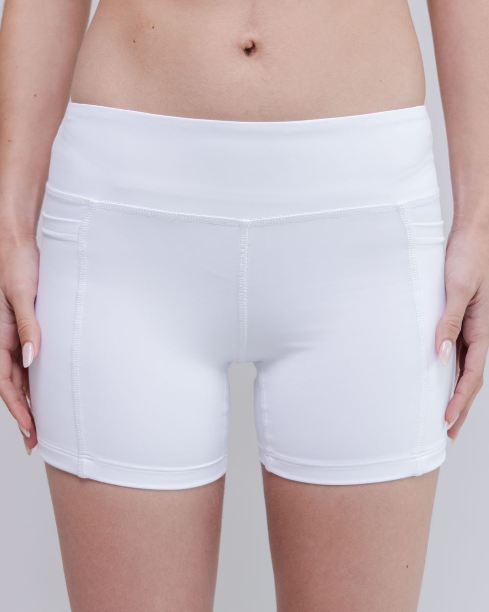 White athletic shorts worn by a person on a plain background