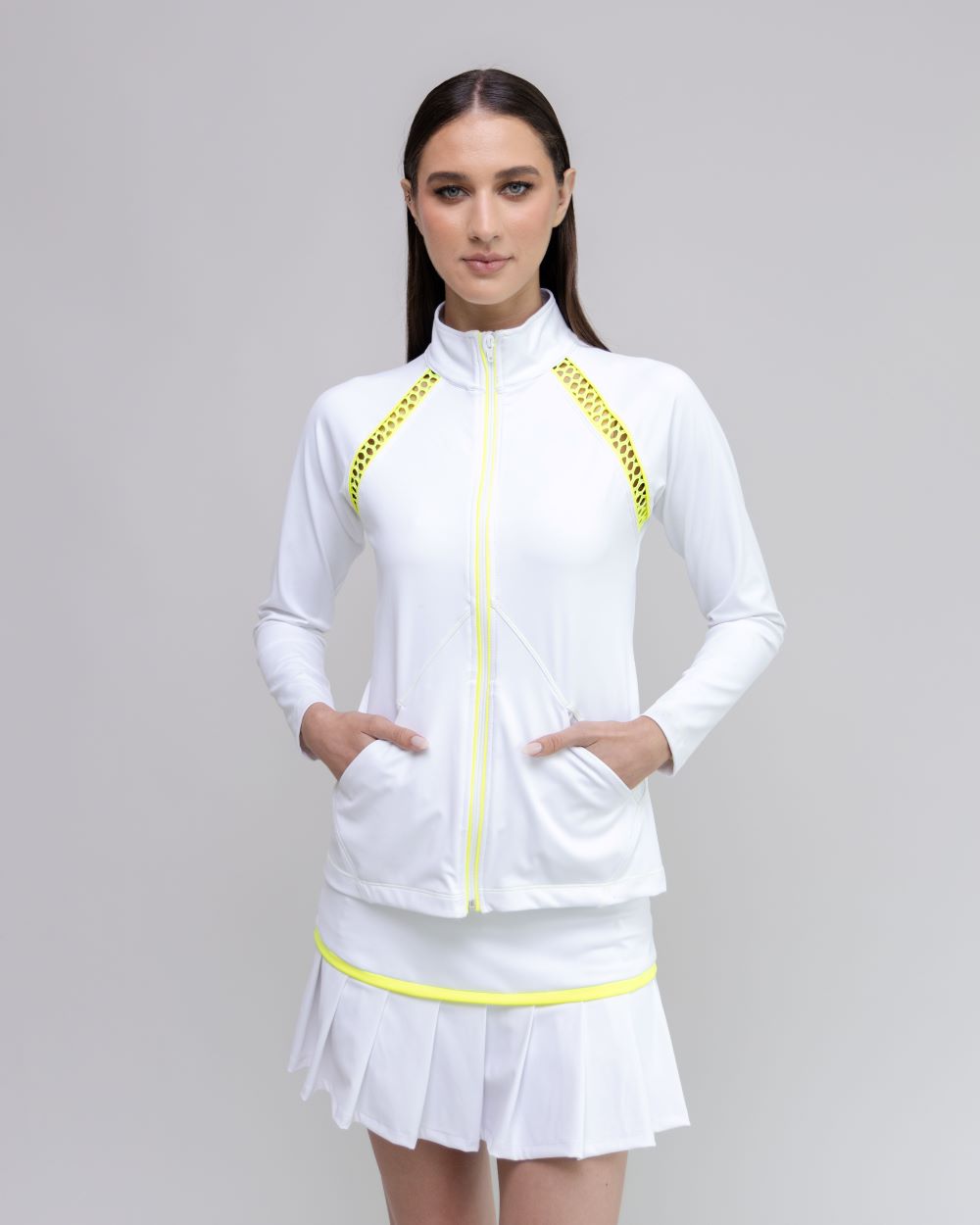 Woman wearing a white outfit with yellow accents on a gray background