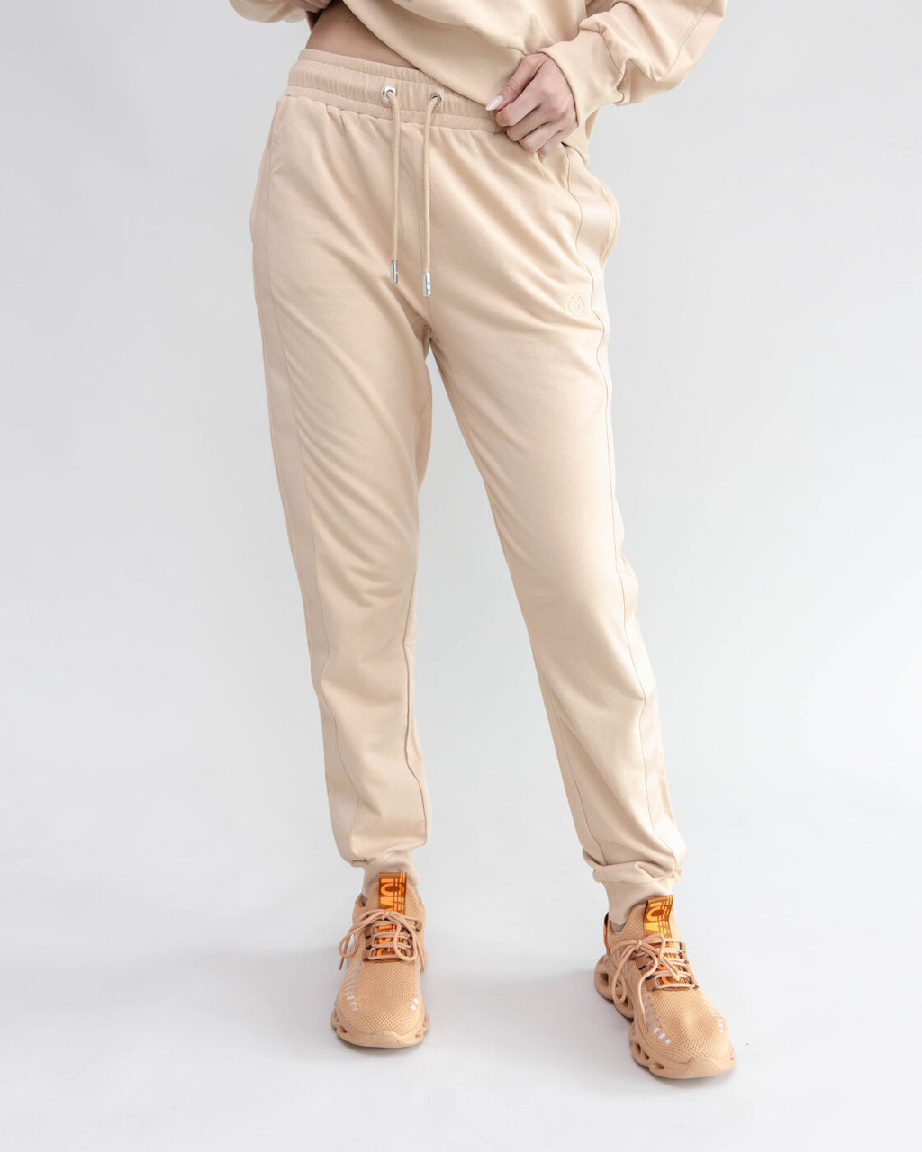 Person wearing beige pants and shoes on a white background