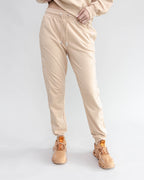 Person wearing beige pants and shoes on a white background