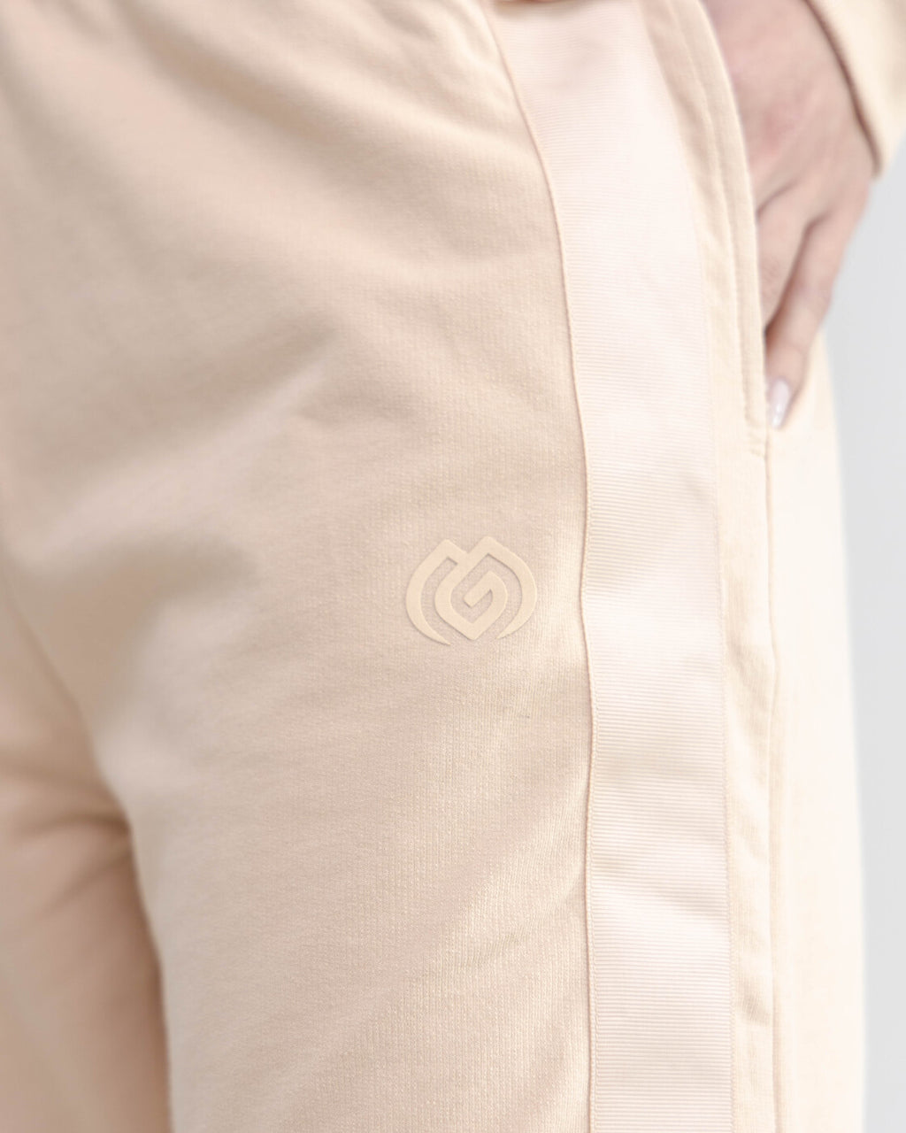 Close-up of a beige jacket with a logo on a light gray background