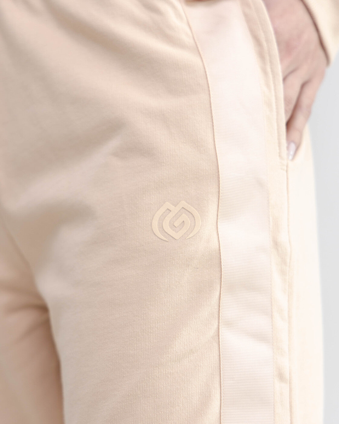 Close-up of a beige jacket with a logo on a light gray background