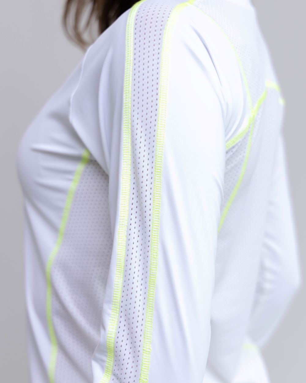 White athletic shirt with neon green accents on a plain background