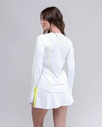 Woman wearing a white athletic outfit with yellow accents on a gray background