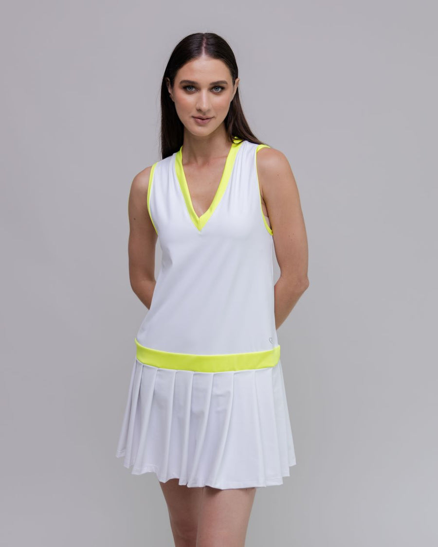 Woman wearing a white dress with yellow accents on a gray background