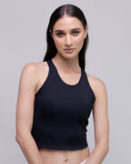 Woman wearing a black tank top against a gray background