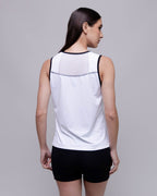 Woman wearing a white sleeveless top with black accents on a gray background