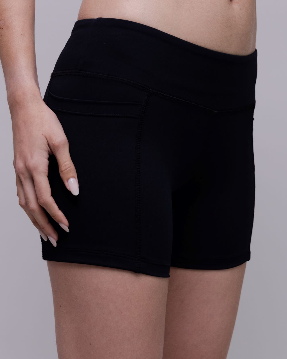 Black shorts worn by a person on a plain background