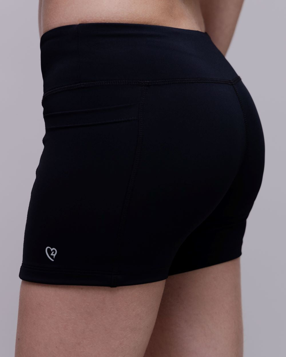 Black athletic shorts worn by a person on a plain background