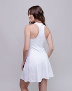 Woman wearing a white dress against a plain background