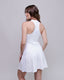 Woman wearing a white dress against a plain background