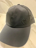 Black cap with a heart design on a beige background
