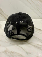 Black cap with heart patterns on a marble surface